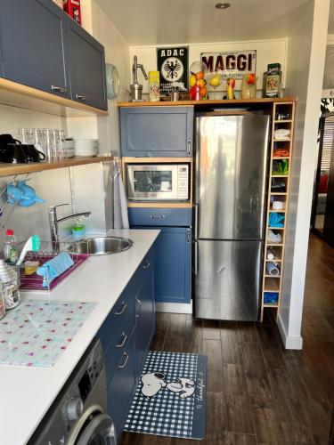 a kitchen with blue cabinets and a stainless steel refrigerator at Prospect House in London