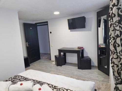 a bedroom with a bed and a table and a television at Casa Thor in Sinaia