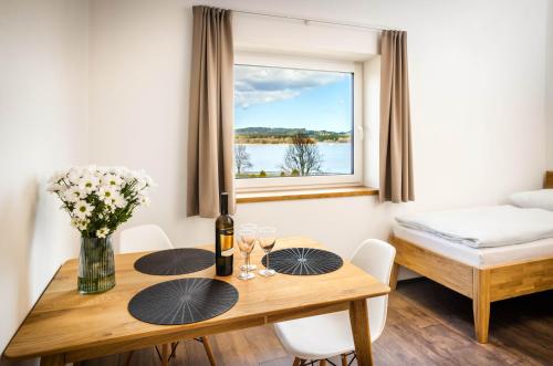 a dining room with a table and a window at Apartmány Panelka Costa Plana Lipno in Černá v Pošumaví