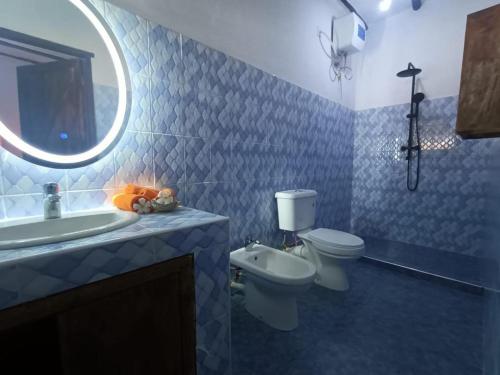 a bathroom with a toilet and a sink and a mirror at SAMAKI VILLAGE in Watamu