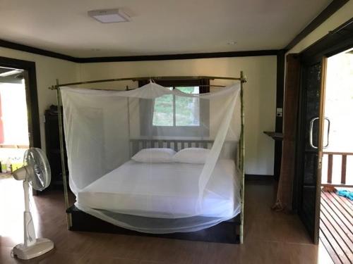 a bedroom with a bed with a mosquito net at Loma Sea Views in Ko Jum