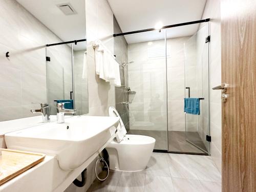 Un baño con lavabo, inodoro y ducha. en HERA HOSTEL, en Chau Doc