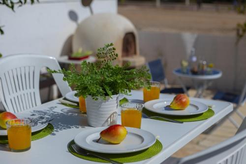 a table with plates of fruit and glasses of orange juice at Melis Villa - Charming villa in Central Protaras in Protaras