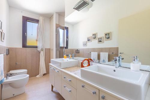 een badkamer met 2 wastafels en een toilet bij Villa Carmen by Perle di Puglia in Morciano di Leuca