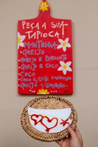 een persoon die een kom voor een schilderij houdt bij Pousada Casamar in Porto De Galinhas