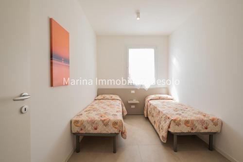1 Schlafzimmer mit 2 Betten und einem Fenster in der Unterkunft PER MAR in Lido di Jesolo