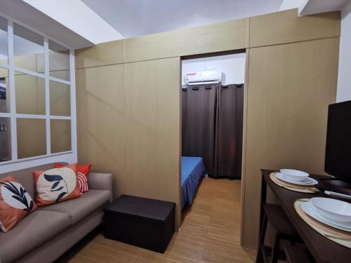 a small room with a couch and a shower at Liam's Pad at grace residences in Manila
