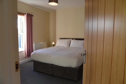 a bedroom with a large bed and a window at Mid Wales Holiday Lets, Rhayader in Rhayader