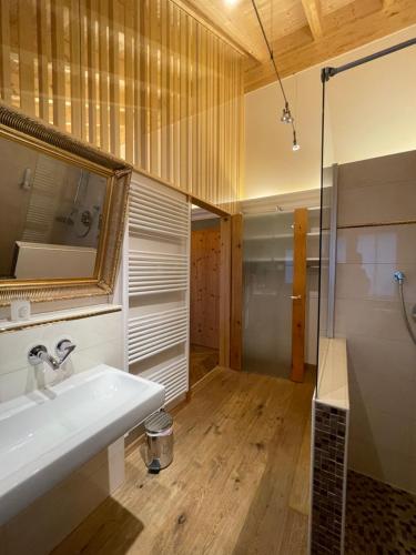 a bathroom with a sink and a mirror and a shower at Landhaus Kössel in Füssen