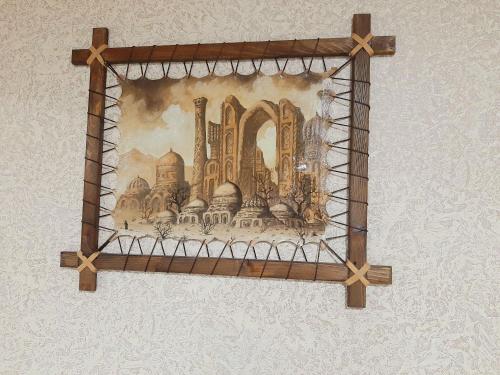 a picture hanging on a wall with a wooden frame at Hotel Mohina in Samarkand
