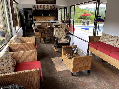 a living room with chairs and tables and a pool at Casa ambiente rural La Vega Cundinamarca in La Vega