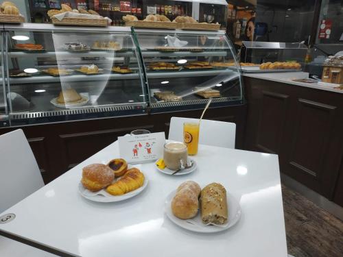 a table with two plates of pastries and a cup of coffee at River 9 and City View Porto Gaia by MP in Vila Nova de Gaia