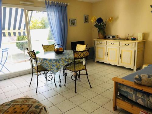 une cuisine avec une table et des chaises dans une pièce dans l'établissement Appartement T2 à Arcachon à 400m de la plage avec balcon et parking privé - FR-1-433-48, à Arcachon