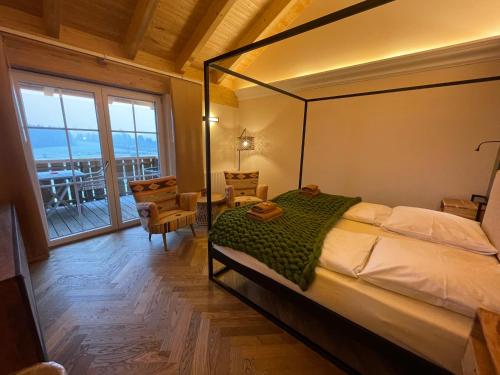 a bedroom with a canopy bed and a balcony at Landhaus Kössel in Füssen