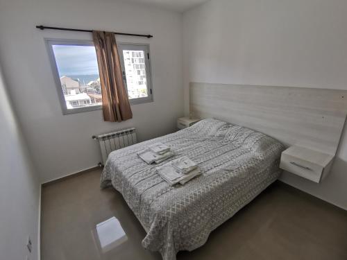 Habitación pequeña con cama y ventana en Puerto Madryn Temporarios en Puerto Madryn