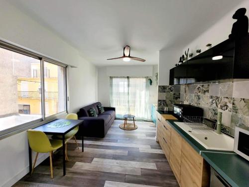 uma cozinha e sala de estar com um sofá e uma mesa em AS22776 - Charmant studio au cœur du centre ville à 2 pas de la plage em Le Grau-du-Roi