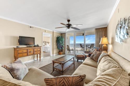 a living room with a couch and a tv at SeaSpray East 323- Gulf Front in Perdido Key