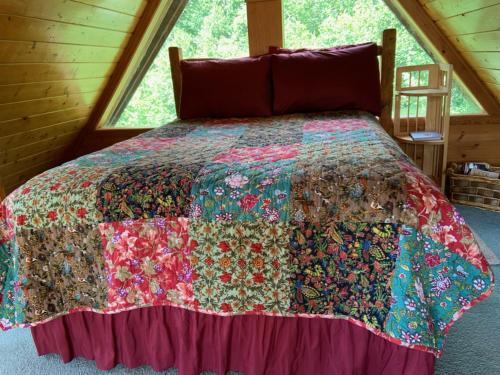a bed with a colorful quilt on it in a room at Alaska Adventure Cabins in Homer