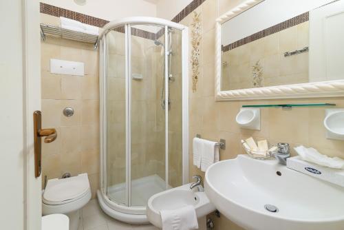 a bathroom with a shower and a sink and a toilet at Universal Hotel in Cervia