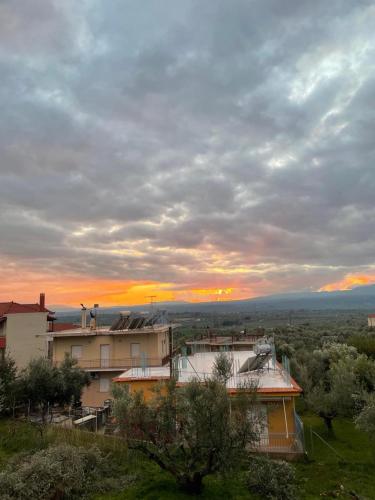 a view of a building with the sunset in the background at Μεζονέτα 5 υπνοδωμάτια, πλήρως εξοπλισμένη και με φορτιστή ηλεκτρικού αυτοκινήτου in Arfará