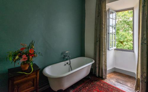 een bad in een groene badkamer met een raam bij Château Garinie 13th Century Medieval castle in the south of France in Lugan