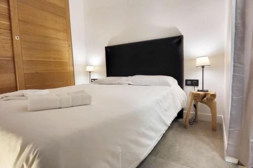 - une chambre avec un grand lit blanc et une tête de lit noire dans l'établissement Appartement T2 Comfy - Rdc - Plage 50m - Rue gratuite, à Saint-Malo