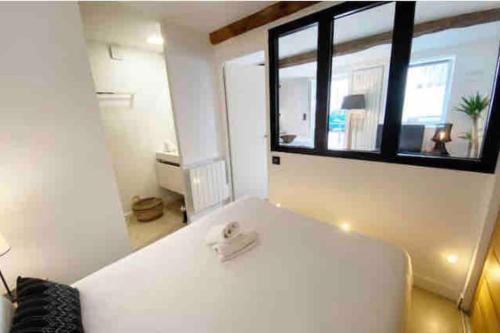 un lit blanc dans une chambre avec une fenêtre dans l'établissement Appartement T2 Comfy - Rdc - Plage 50m - Rue gratuite, à Saint-Malo