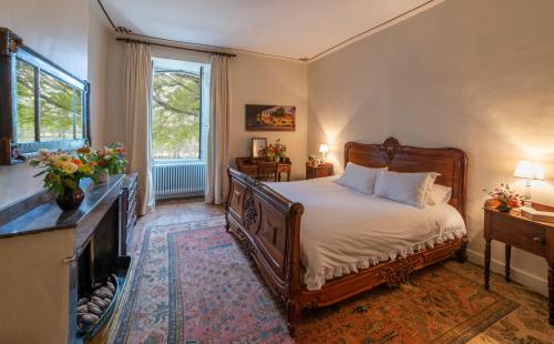 um quarto com uma cama grande e uma lareira em Château Garinie 13th Century Medieval castle in the south of France em Lugan