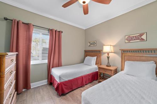 a bedroom with two beds and a ceiling fan at SeaSpray West 105- Gulf Front in Perdido Key