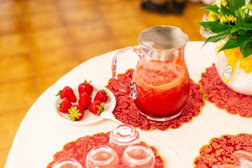 a table with a cup of tea and strawberries at Universal Hotel in Cervia