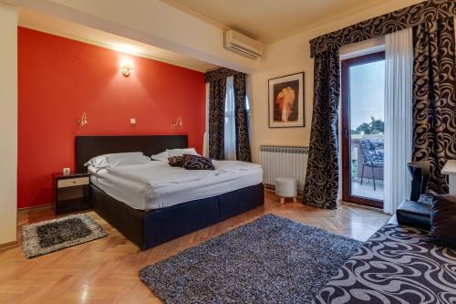 ザダルにあるHotel Marinkoの赤い壁のベッドルーム1室(ベッド1台付)
