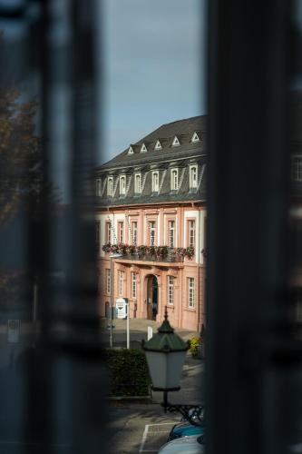 a large pink building with a balcony at Gasthause Zur Krone Hotel in Leimen