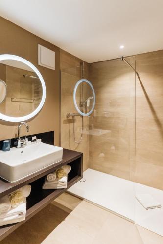 a bathroom with a sink and a shower at COURT HOTEL in Halle Westfalen