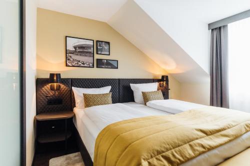 - une chambre avec un grand lit et une fenêtre dans l'établissement COURT HOTEL, à Halle Westfalen