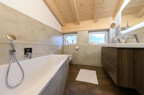 ein großes Bad mit einer Badewanne und einem Waschbecken in der Unterkunft Alpjuwel in Garmisch-Partenkirchen