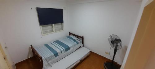 a small bedroom with a bed and a window at Departamento Malvinas in Corrientes