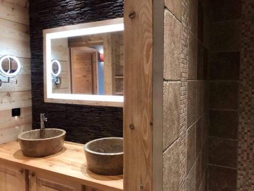 a bathroom with two sinks and a mirror at Luxury chalet Léli in Saint-Chaffrey