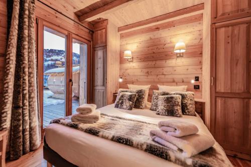 um quarto com uma cama num chalé de madeira em Luxury chalet Léli em Saint-Chaffrey