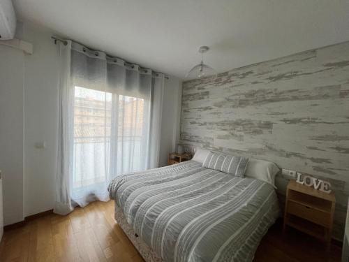 1 dormitorio con 1 cama con pared de madera en Llano Santa Isabel, en Zaragoza