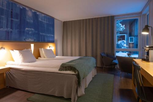 ein Hotelzimmer mit einem großen Bett und einem Fenster in der Unterkunft Icehotel in Jukkasjärvi