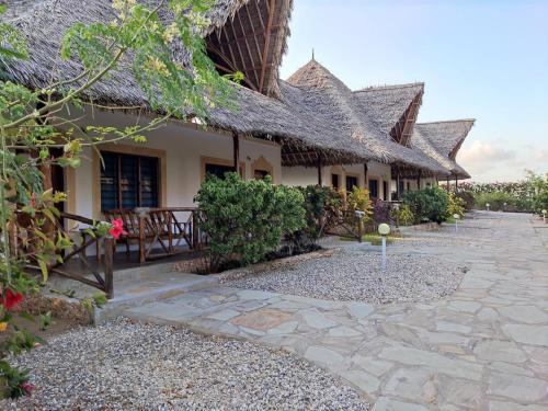 a building with a stone walkway in front of it at BeB Sardegna2 Anjumasa village in Watamu