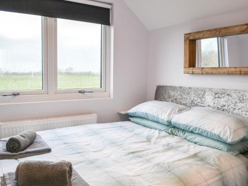 a bedroom with a bed and two windows at Hanoverian Suite - Uk41830 in Tickton