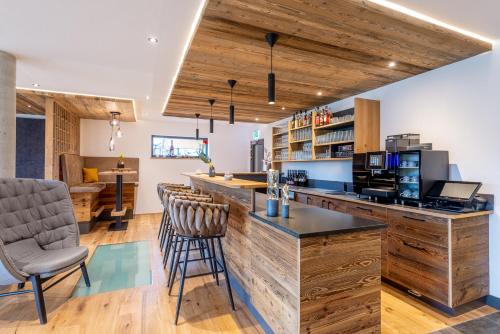 a kitchen with a counter with chairs and a bar at Hotel Bergflair in Fischen