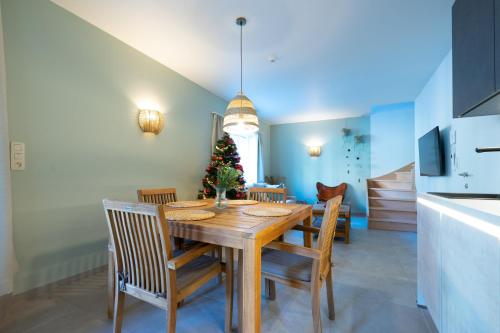 een eetkamer met een tafel met stoelen en een kerstboom bij Ardn-bnb Bike n Bed in La-Roche-en-Ardenne