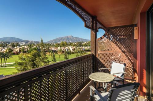 a balcony with a table and chairs and mountains at Barceló Marbella in Marbella