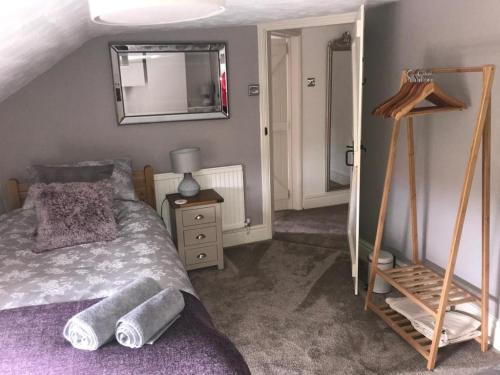 a bedroom with a bed and a mirror on the wall at Curlew Cottage in Sedgeford