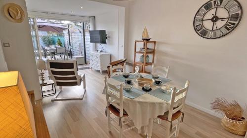 une salle à manger avec une table et une horloge au mur dans l'établissement Mazet Saquèdes 11, à Sainte-Maxime