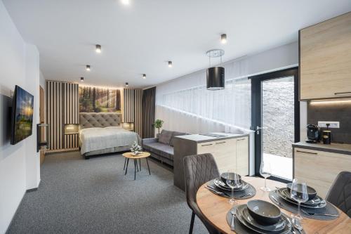 a kitchen and living room with a table and chairs at Chalet - Apartmán Malinô HRABOVO in Ružomberok