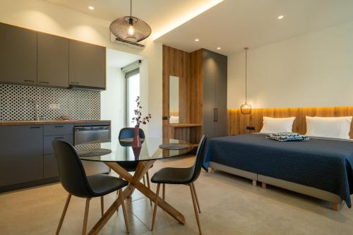 1 dormitorio con 1 cama, mesa y sillas en Esperos Studios and Apartments, #3 and #4, en Stalida