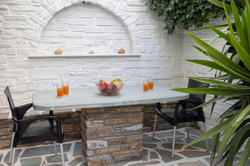 een stenen muur met een tafel en stoelen bij Studios Alsos in Naxos Chora